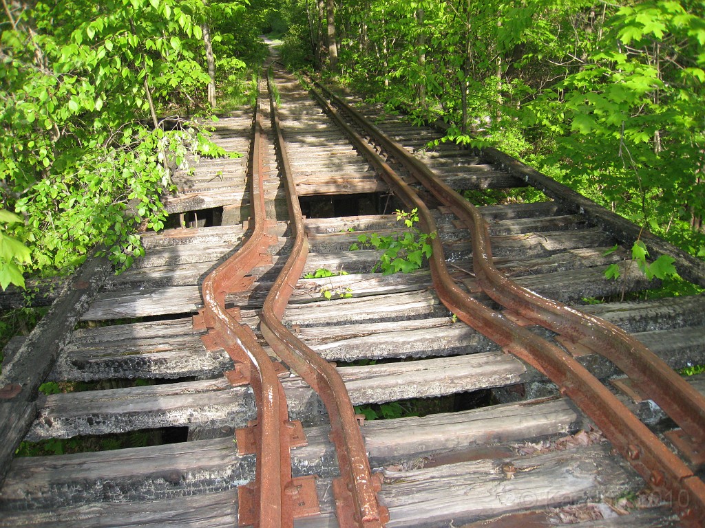 Tilton NH Rail Trail 2010 0235.jpg - I am intrigued as to what may have bent all four of these rails so abruptly. The ties do not appear to be shifted out of position. Was it intentional to prevent trains from going over the trestle? How much force did it take to bend this this way?